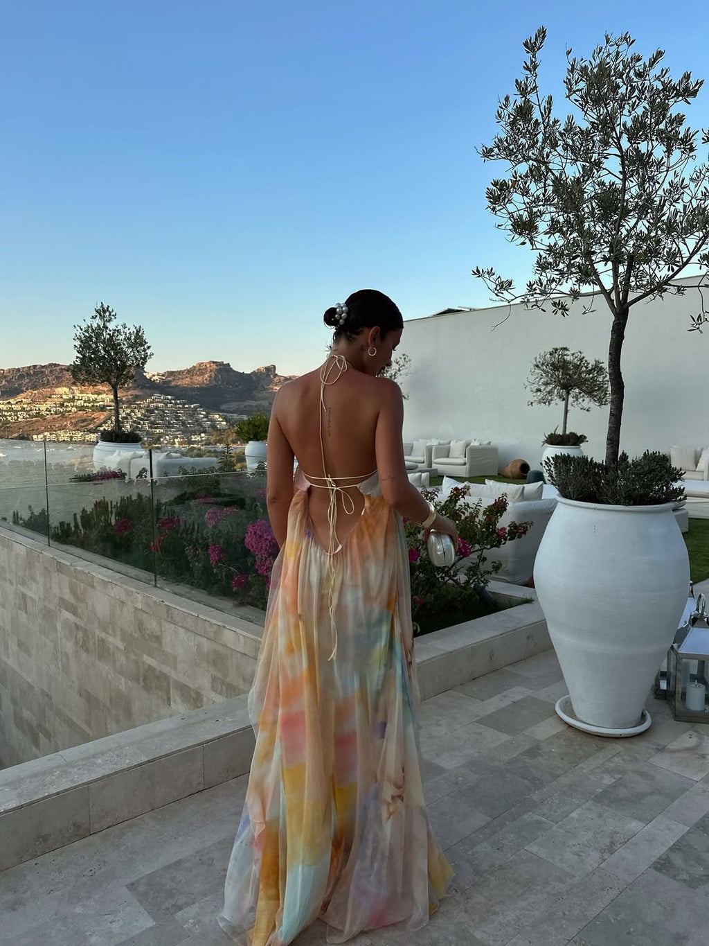 Orange printed halter maxi dress, rear view showing backless design, maxi length