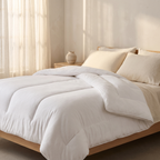 The Meringue Comforter in White, made up on a bed